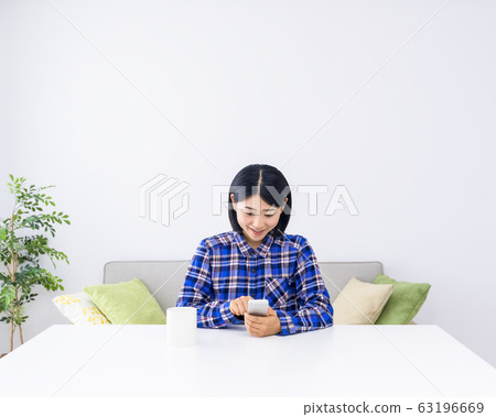 A woman smiling in his room to relax A woman smiling in his room to relax 63196669