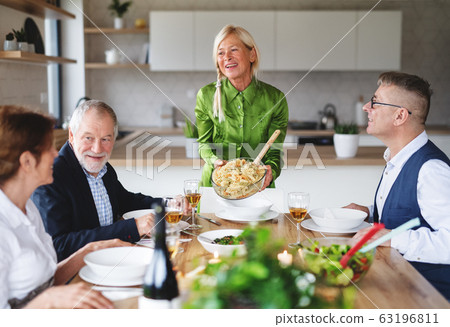 Group of senior friends at dinner party at home. Group of senior friends at dinner party at home. 63196811