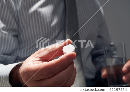 businessman with a pill, hands close view - businessman with a pill, hands close view - 63197254