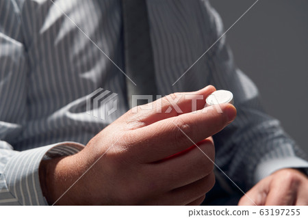 businessman with a pill, hands close view - businessman with a pill, hands close view - 63197255