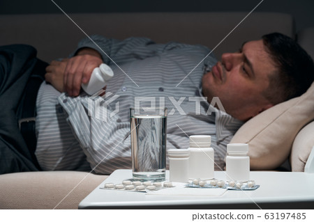 Overworked businessman is lying on the sofa and Overworked businessman is lying on the sofa and 63197485