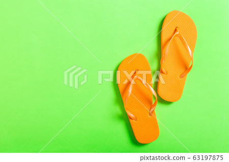 orange flip flops on green background. Top view orange flip flops on green background. Top view 63197875