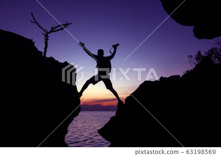 Silhouette of the photographer jumping over the Silhouette of the photographer jumping over the 63198569