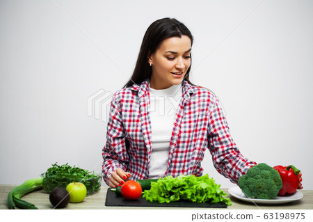 Concept of diet and healthy eating girl with vegetables on the background of the white wall Concept of diet and healthy eating girl with vegetables on the background of the white wall 63198975