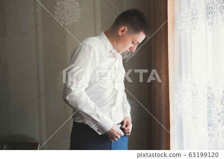 Young handsome man relaxing at his apartment in a hotel after business meeting 63199120