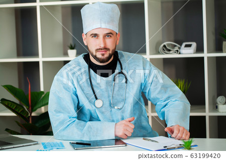 Young doctor is waiting for a patient in the clinic's office 63199420