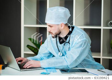 Young doctor is waiting for a patient in the clinic's office 63199421