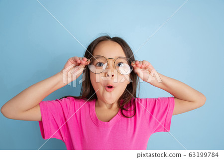 Caucasian little girl's portrait on blue studio background 63199784