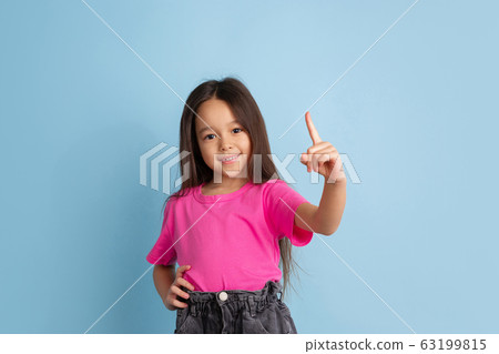 Caucasian little girl's portrait on blue studio background 63199815