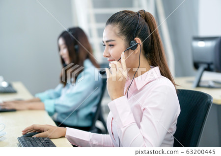 Young female operator with headphone Young female operator with headphone 63200445
