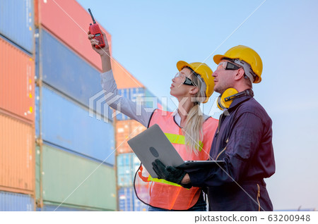Worker woman use walkie-talkie point to some directions and discuss with technician man Worker woman use walkie-talkie point to some directions and discuss with technician man 63200948