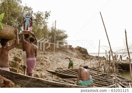 The Village People of Rural India lifting Goddess Idol before immersion in Ichhamati River. The Village People of Rural India lifting Goddess Idol before immersion in Ichhamati River. 63201125