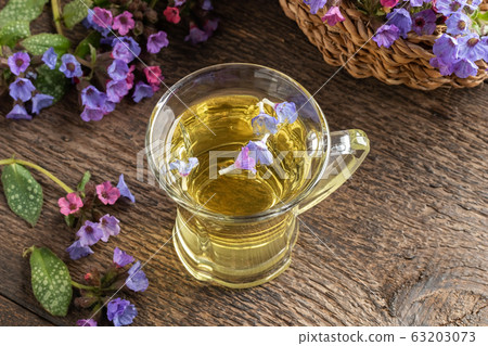 A cup of herbal tea with fresh lungwort or pulmonaria flowers 63203073