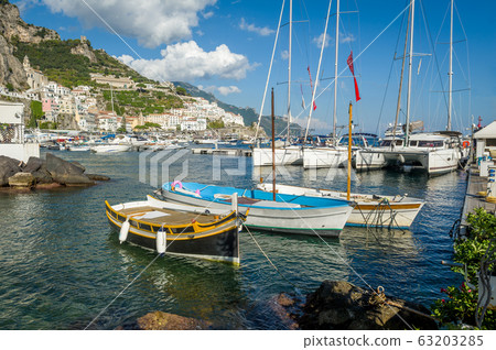 Traditional boats and modern yachts docked at Amalfi marina 63203285