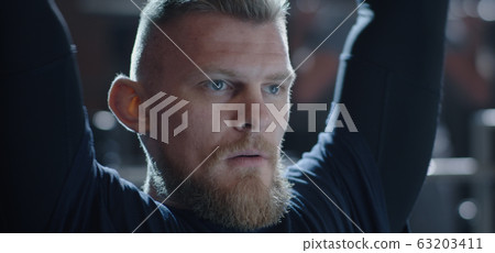 Young man lifting weight in gym 63203411