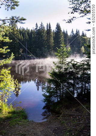 Morning haze over surface of the Pohorsky pond know as Jiricka reservoir near Pohorska Ves, Novohradske Mountains, Cesky Krumlov District, South Bohemian Region, Czech Repubic Morning haze over surface of the Pohorsky pond know as Jiricka reservoir near Pohorska Ves, Novohradske Mountains, Cesky Krumlov District, South Bohemian Region, Czech Repubic 63203550