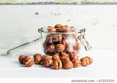 Hazelnuts with sugar icing in jar. Hazelnuts with sugar icing in jar. 63203559