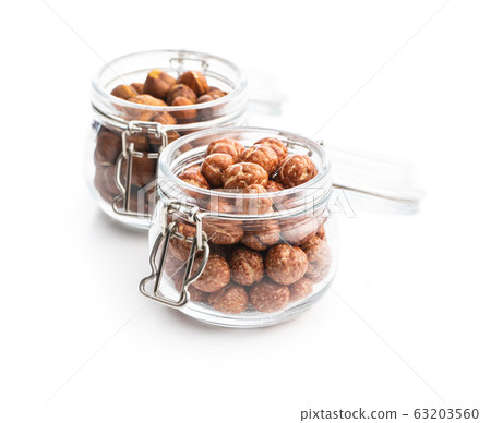 Hazelnuts with sugar icing in jar. Hazelnuts with sugar icing in jar. 63203560