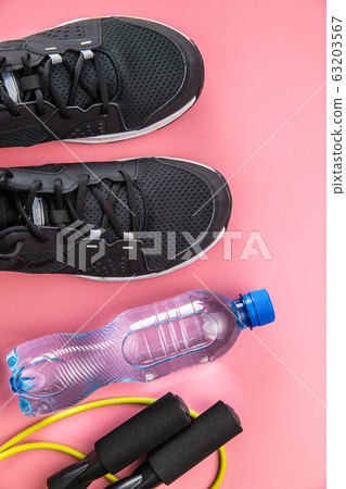 Black sport shoes, jump rope and bottle of water. Black sport shoes, jump rope and bottle of water. 63203567