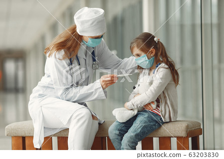 Doctor and a child in protective masks are in hospital 63203830