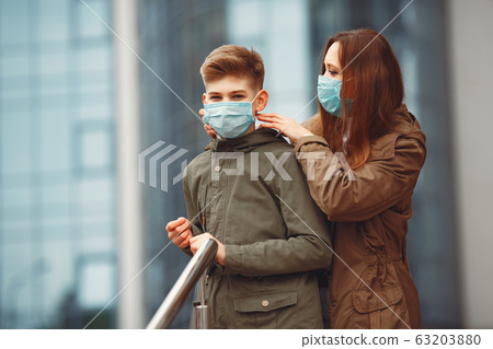 Mother and son are wearing disposable masks 63203880