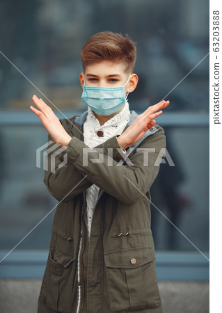 A boy in a disposable mask crossing arms 63203888
