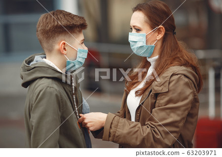 A boy and mother are wearing protective masks 63203971