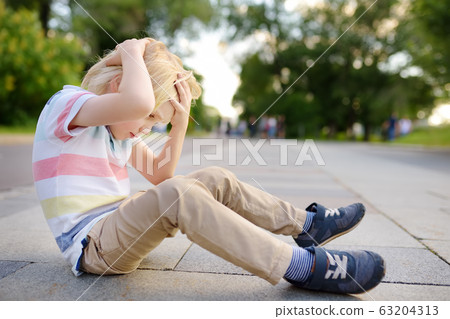 Little boy fell in the street, hit his head. Little boy fell in the street, hit his head. 63204313