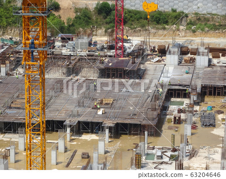 An aerial image of the construction site where the column is actively provided on the slab for the next level. Workers are working in stages. An aerial image of the construction site where the column is actively provided on the slab for the next level. Workers are working in stages. 63204646