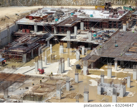 An aerial image of the construction site where the column is actively provided on the slab for the next level. Workers are working in stages. An aerial image of the construction site where the column is actively provided on the slab for the next level. Workers are working in stages. 63204647