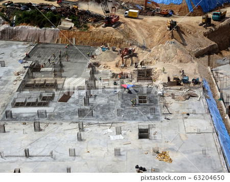 An aerial image of the construction site where the column is actively provided on the slab for the next level. Workers are working in stages. An aerial image of the construction site where the column is actively provided on the slab for the next level. Workers are working in stages. 63204650