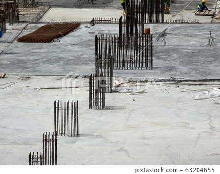 An aerial image of the construction site where the column is actively provided on the slab for the next level. Workers are working in stages. An aerial image of the construction site where the column is actively provided on the slab for the next level. Workers are working in stages. 63204655