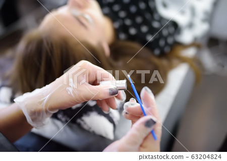 Beautician making eyelash lamination procedures. 63204824