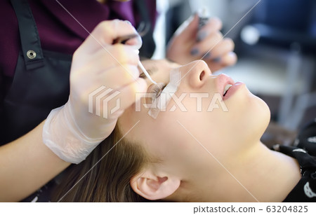 Beautician making eyelash lamination procedures. 63204825