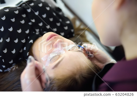 Beautician making eyelash lamination procedures. 63204826