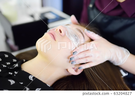 Beautician making eyelash lamination procedures. Beautician making eyelash lamination procedures. 63204827