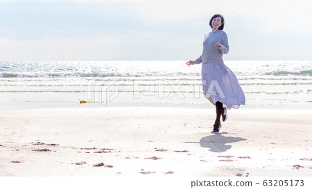 A healthy middle woman playing on the sandy beach Healthy image 63205173