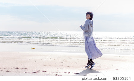 A healthy middle woman playing on the sandy beach Healthy image 63205194