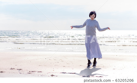 A healthy middle woman playing on the sandy beach Healthy image A healthy middle woman playing on the sandy beach Healthy image 63205206