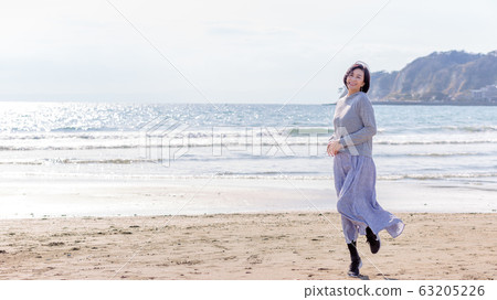 在沙灘上玩耍的健康中年女人健康形象 63205226
