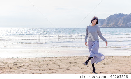 在沙灘上玩耍的健康中年女人健康形象 63205228