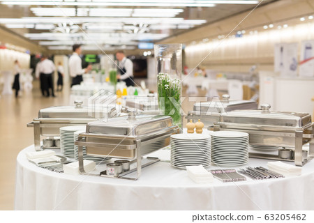 Waiters prepare buffet before a coffee break at business conference meeting. 63205462