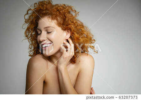 Amazing young woman posing over white background 63207373