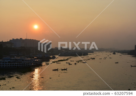 Dhaka in Bangladesh Beautiful sunrise and old cityscape Passenger ship that stops along the Brigonga River Large and small boats crossing the river 63207594