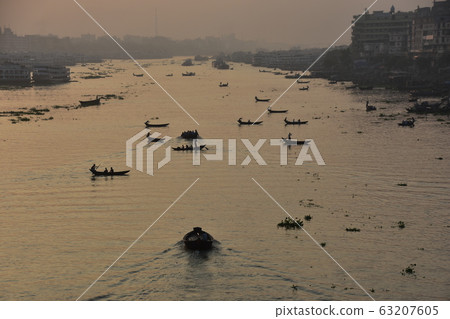 Dhaka in Bangladesh Beautiful sunrise and old cityscape Passenger ship that stops along the Brigonga River Large and small boats crossing the river 63207605