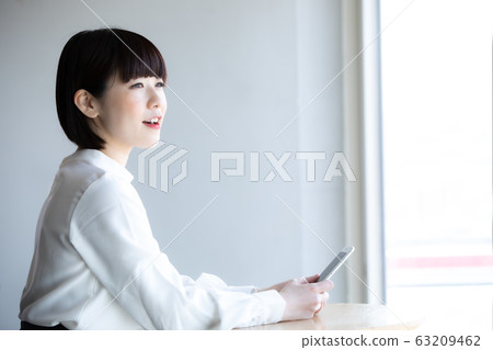 一個女人站在一家咖啡館 63209462