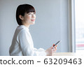 一個女人站在一家咖啡館 63209463