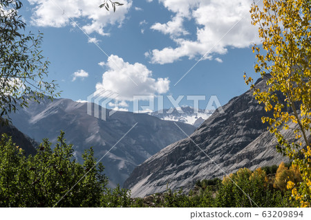 Highland mountain hill range in summer with floating clouds framing the backdrop on Himalayas hiking trails.  63209894