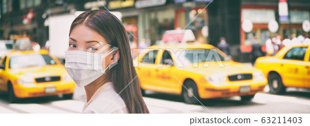 Corona virus travel ban China woman tourist walking in New York city street wearing surgical mask coronavirus protection, outbreak spreading scare. Panoramic banner background of traffic taxi cabs Corona virus travel ban China woman tourist walking in New York city street wearing surgical mask coronavirus protection, outbreak spreading scare. Panoramic banner background of traffic taxi cabs 63211403