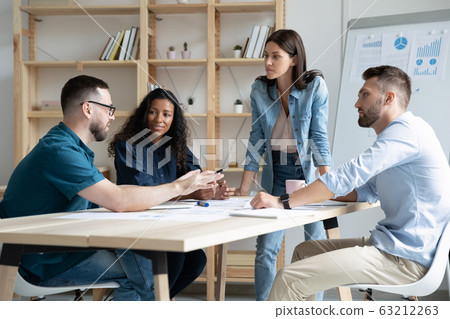 Focused mixed race business people company employees discussing project. Focused mixed race business people company employees discussing project. 63212263